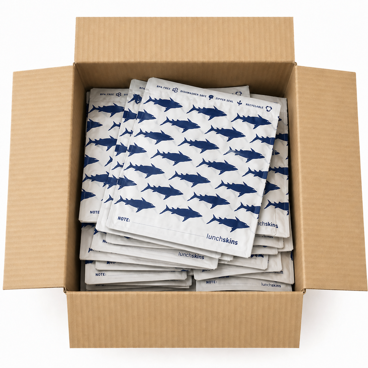 Image of Box filled with multiple white paper bags with blue shark patterns, branded 'lunchskins'.